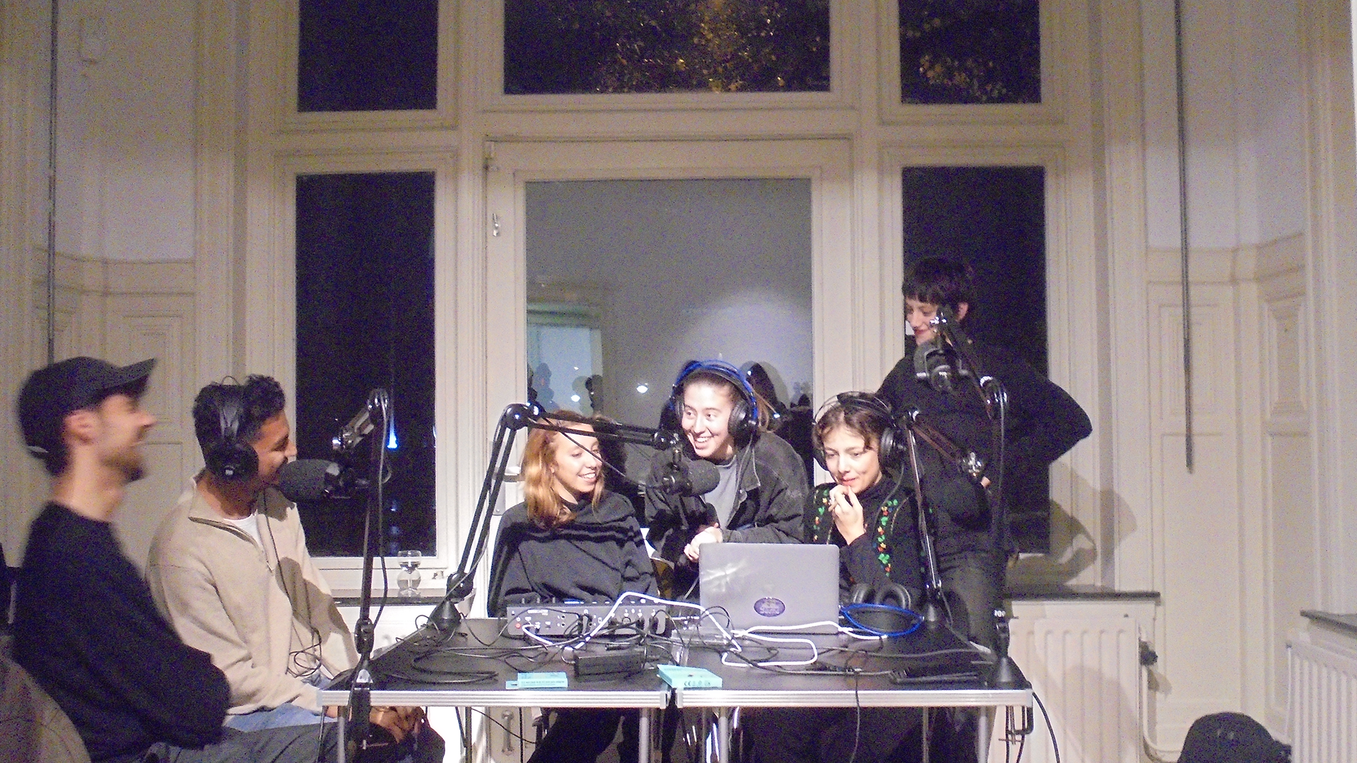 Group of people recording audio and conversations around a rectangular table
