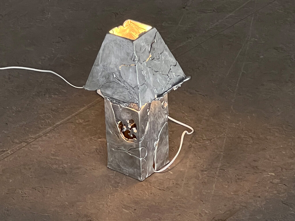 Designed lamp standing on grey floor.