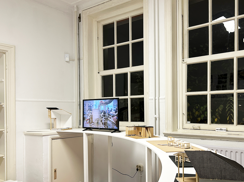 A gently curved table with a screen and miniature models.