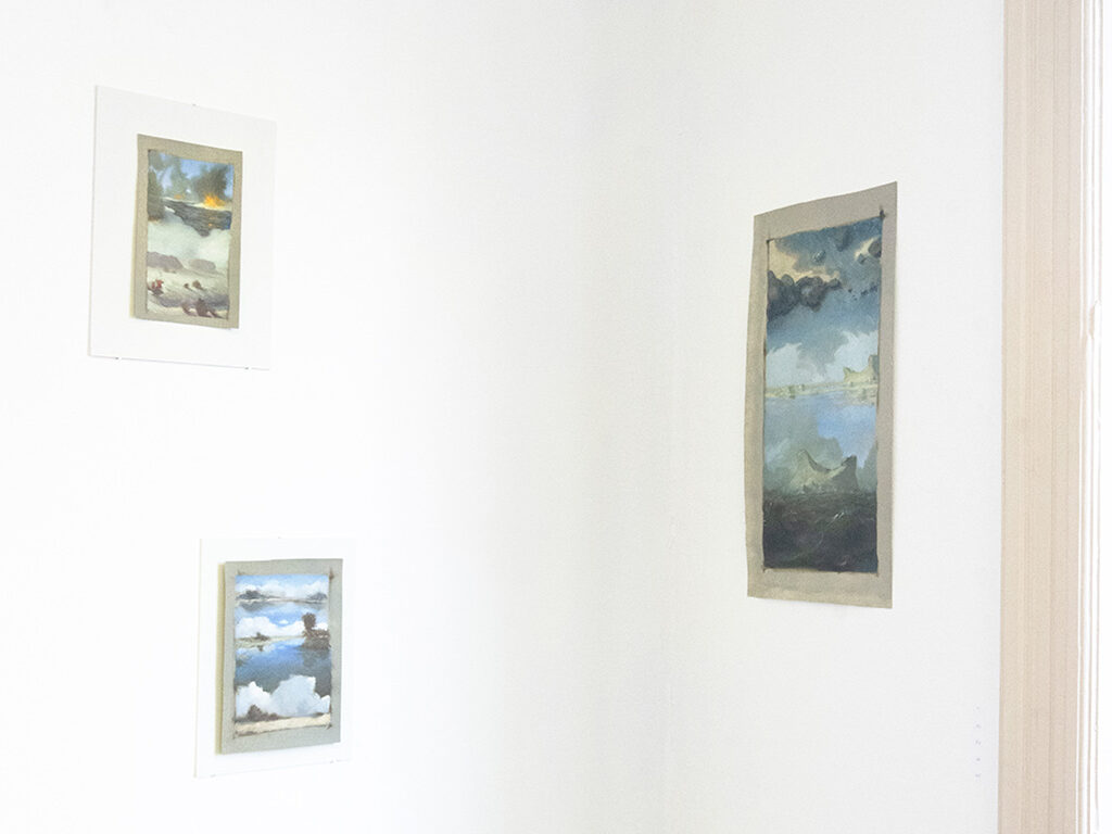 Three landscape art pieces hanging on a white wall
