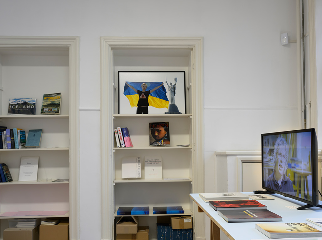 Library full of different books and images. Some are on shelves and some on the table.
