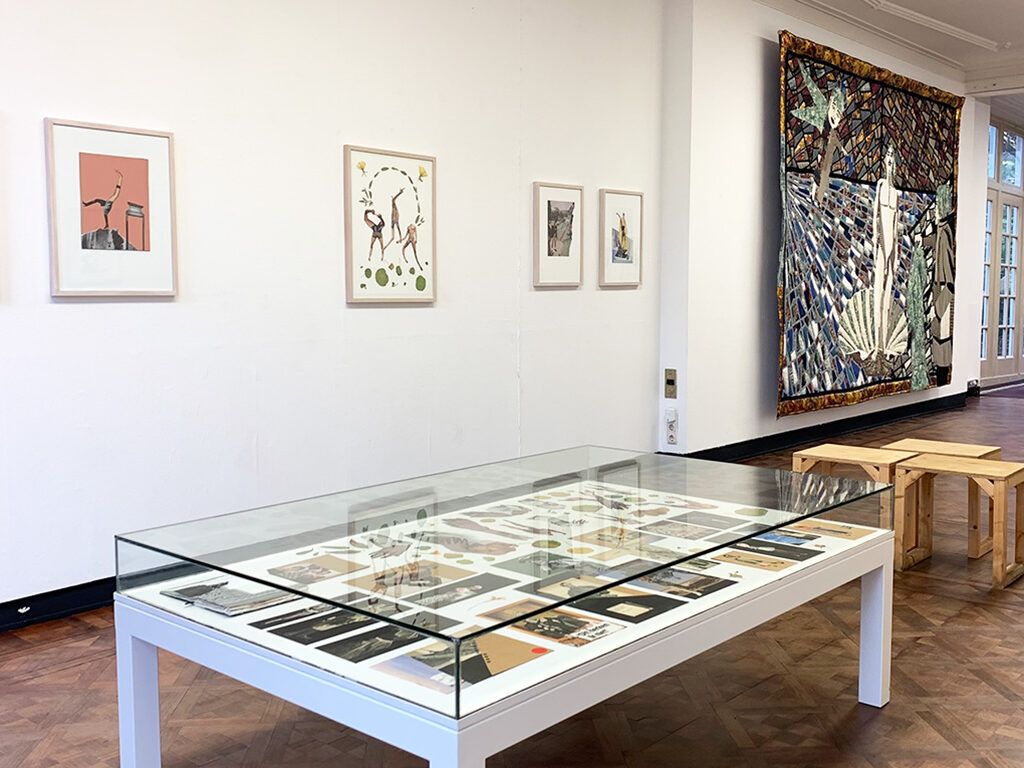 A room with art and textile pieces hanging from the walls or laying on a white table.