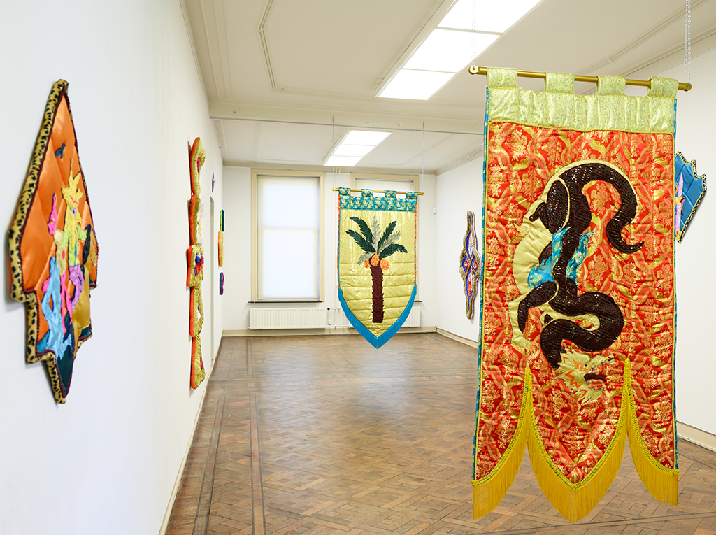 Overview of textile banners, 2 in the middle of a large room, 3 on the walls