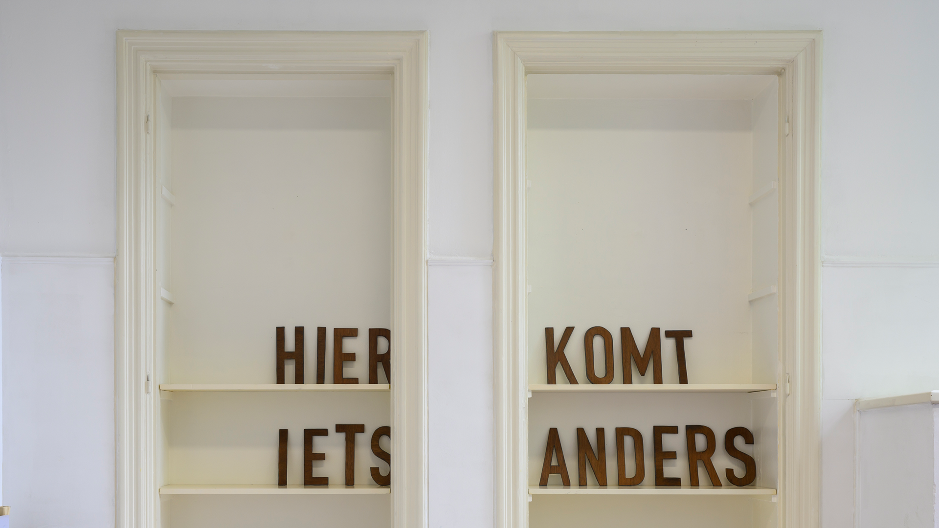 Two door frames fitted with shelves, displaying a few letters on them.
