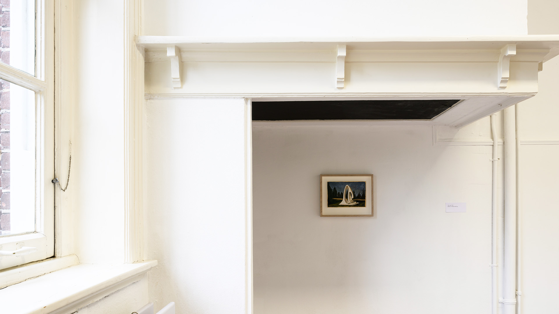 Small artwork hanging on a white wall