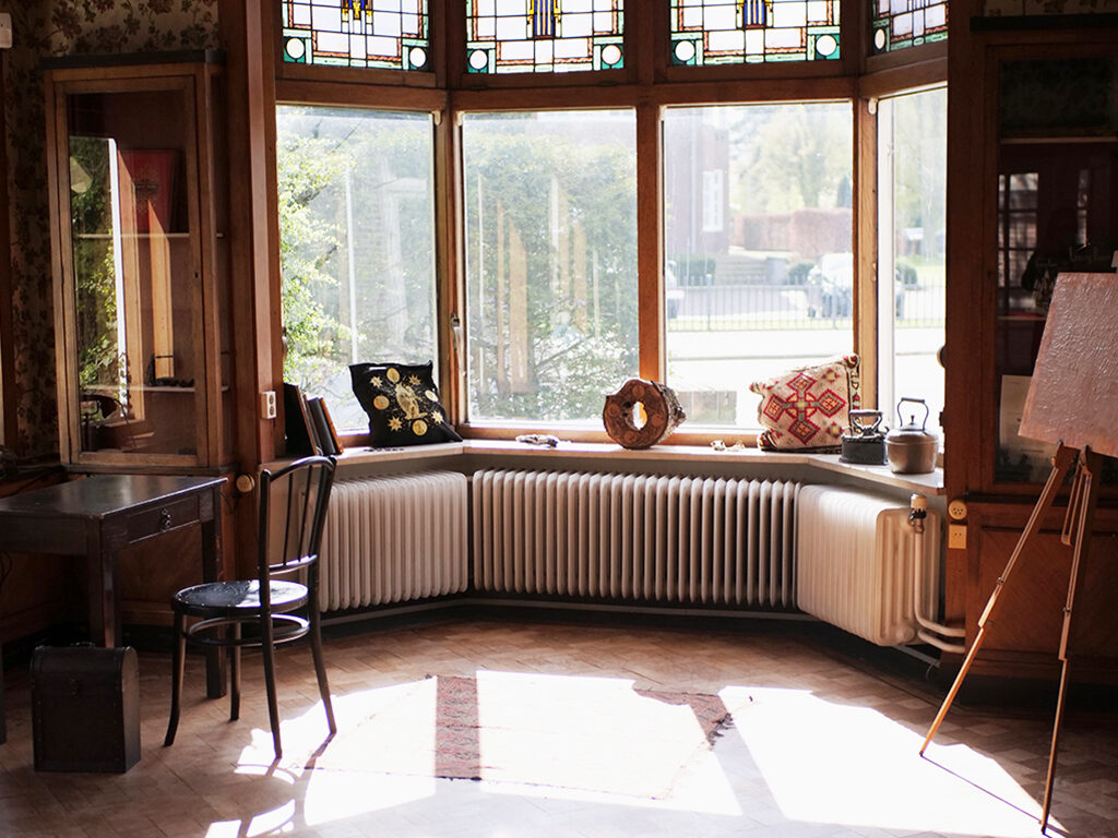 Image of the interior of the house with windows and atributes of the artist placed on the window sill.