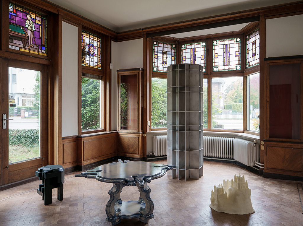 Design-art works exhibited in a historic billiard room.