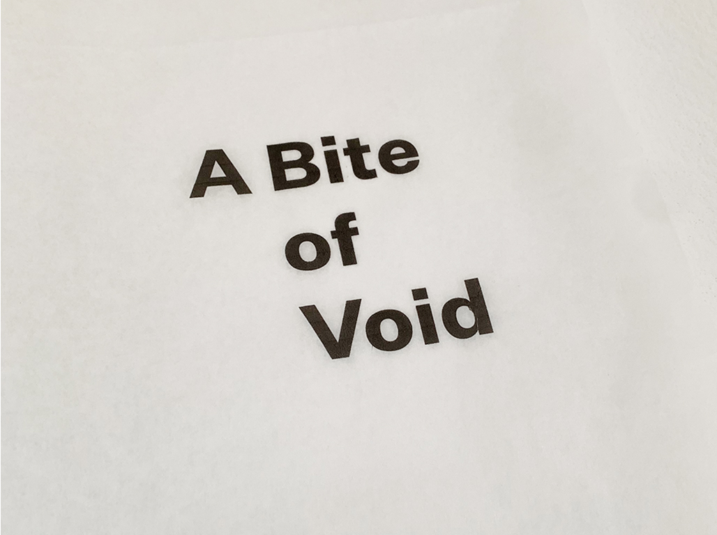 A bite of void written in black on a white wall.