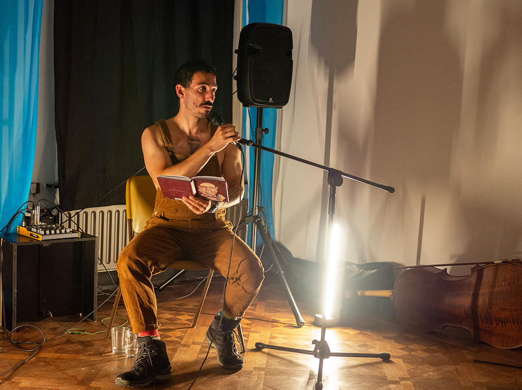 A live musical performance unfolds in a dimly lit white room.