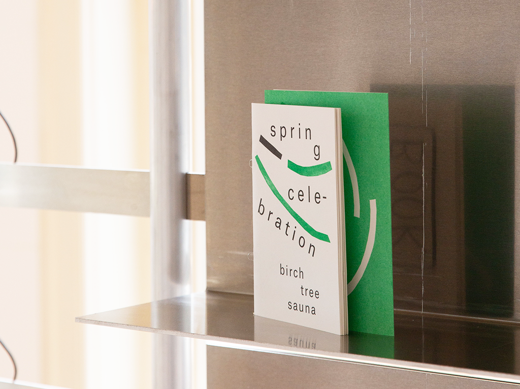 An aluminum bookcase holding two books.