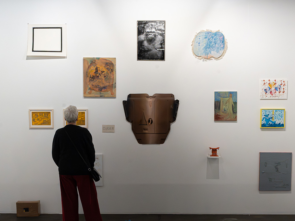 a woman standing in front of a gallery presentation