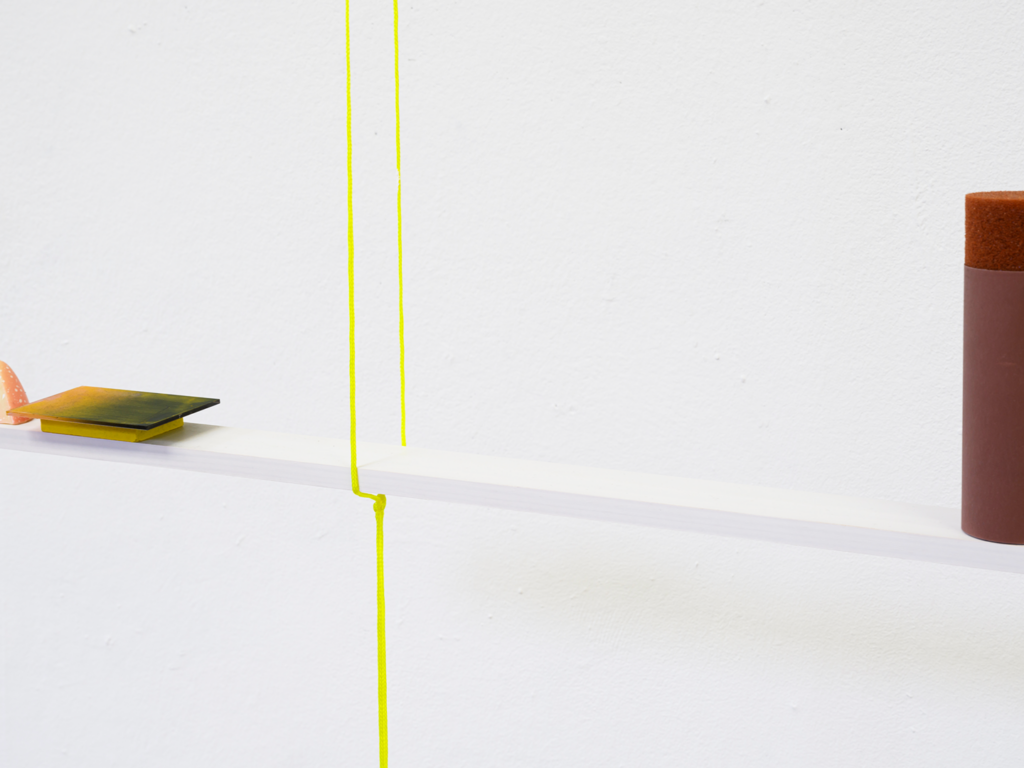 A shelf hanging from the ceiling with two ropes, showcasing an arrangement of small objects.