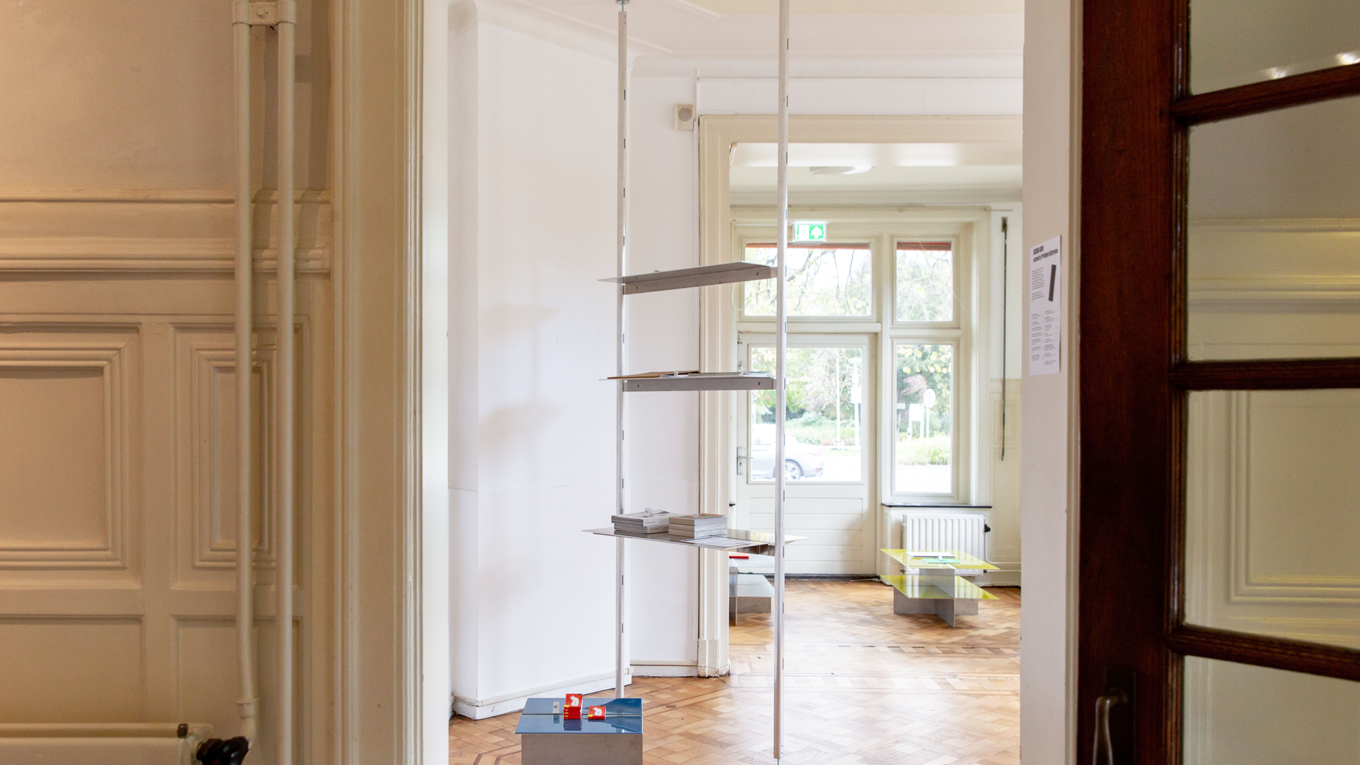 Exterior view of a white room featuring an aluminum bookcase