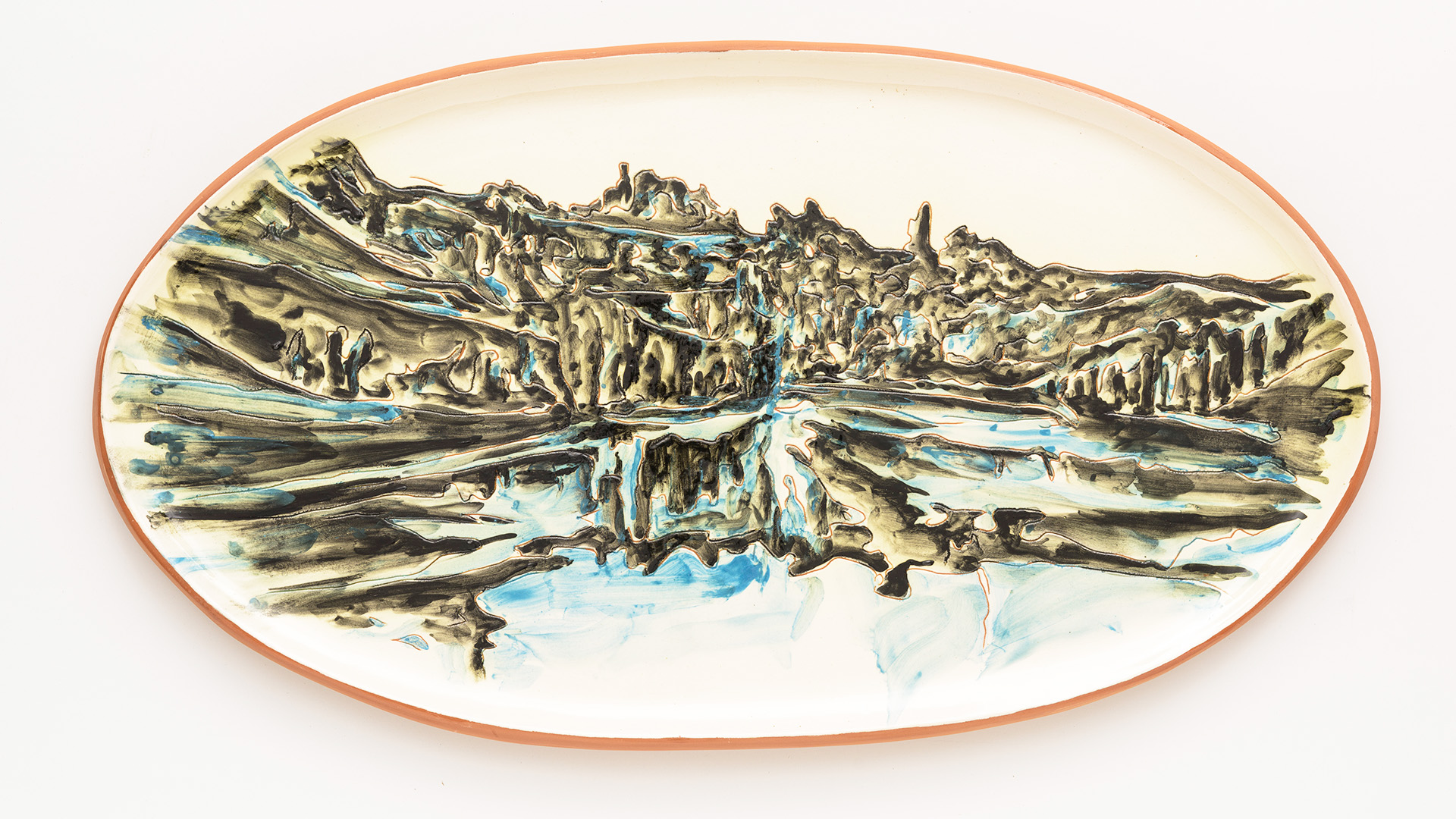 Image of an oval ceramic platter with a terracotta rim, decorated with an abstract green-blue landscape resembling a mountains, forests and waterfalls.