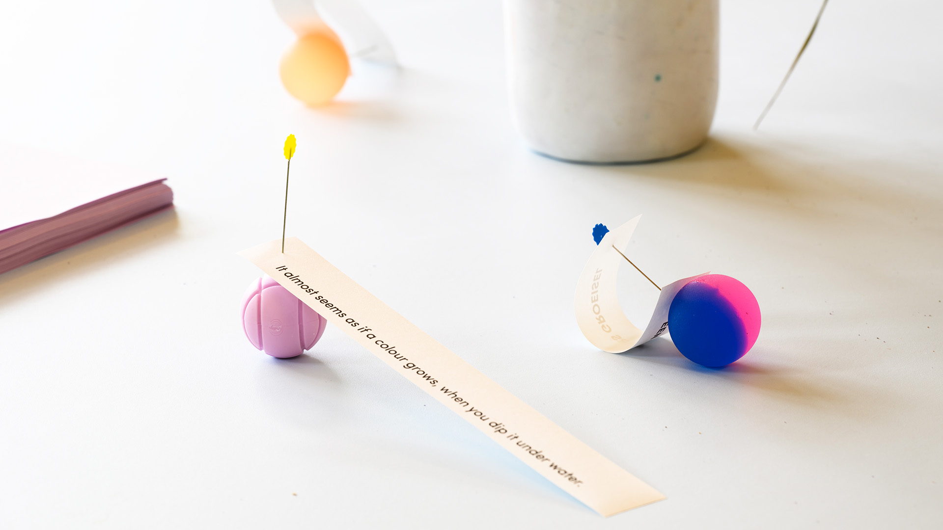 Small colourful objects scattered on a white table.