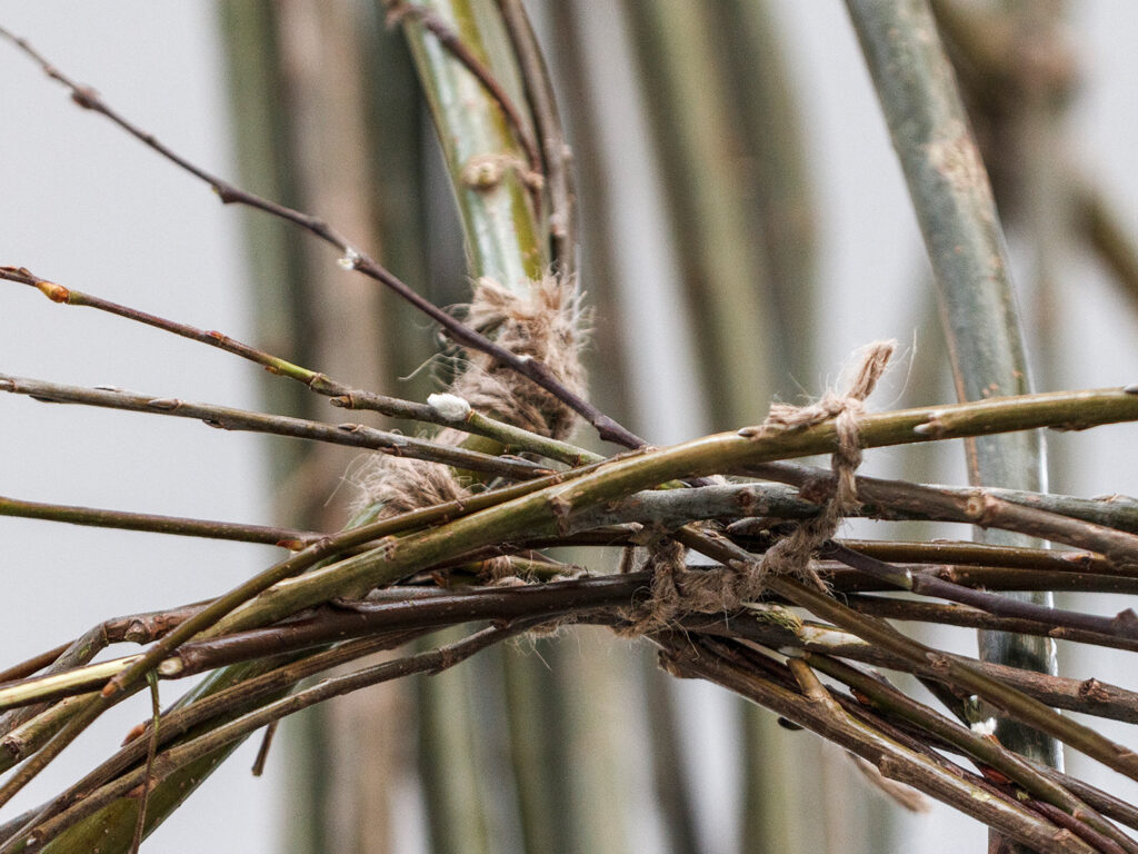 Detailed image of tied branches that make a part of the artwork.