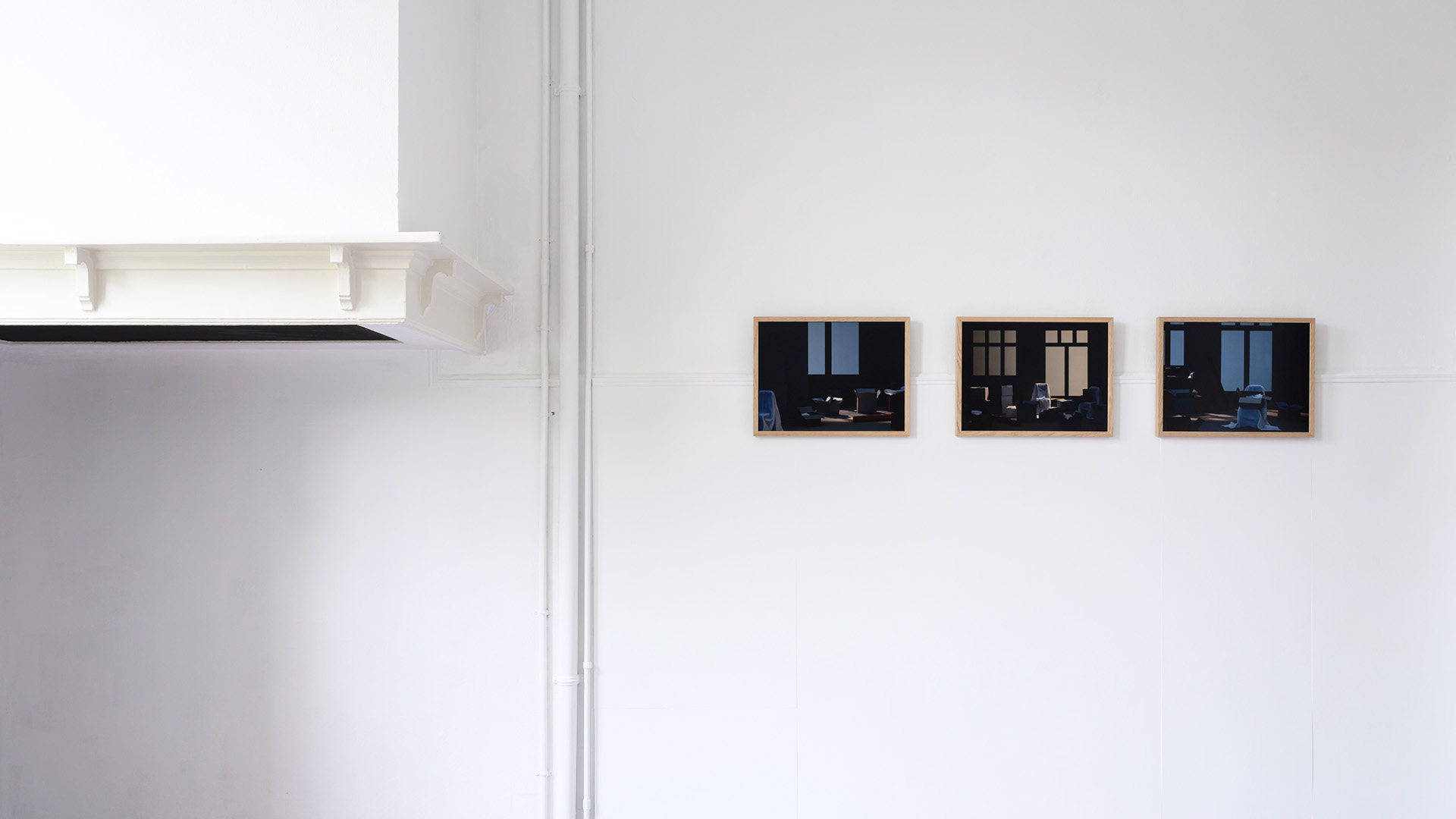 Three frames hanging next to each other on a white wall