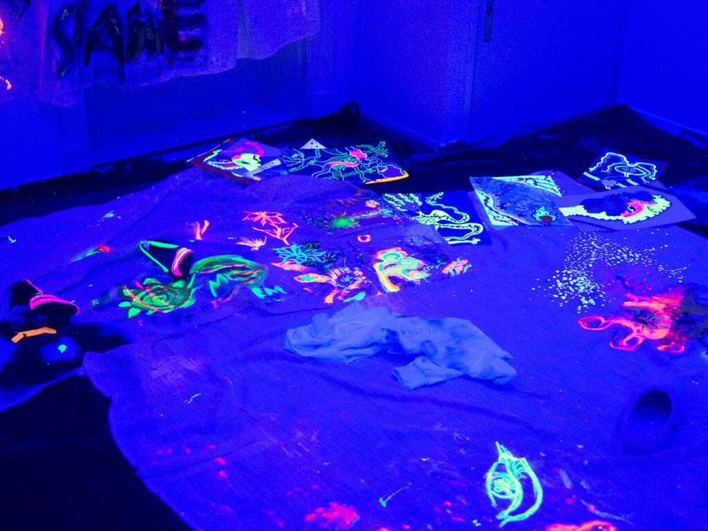 A room with blue light and bright coloured drawings.