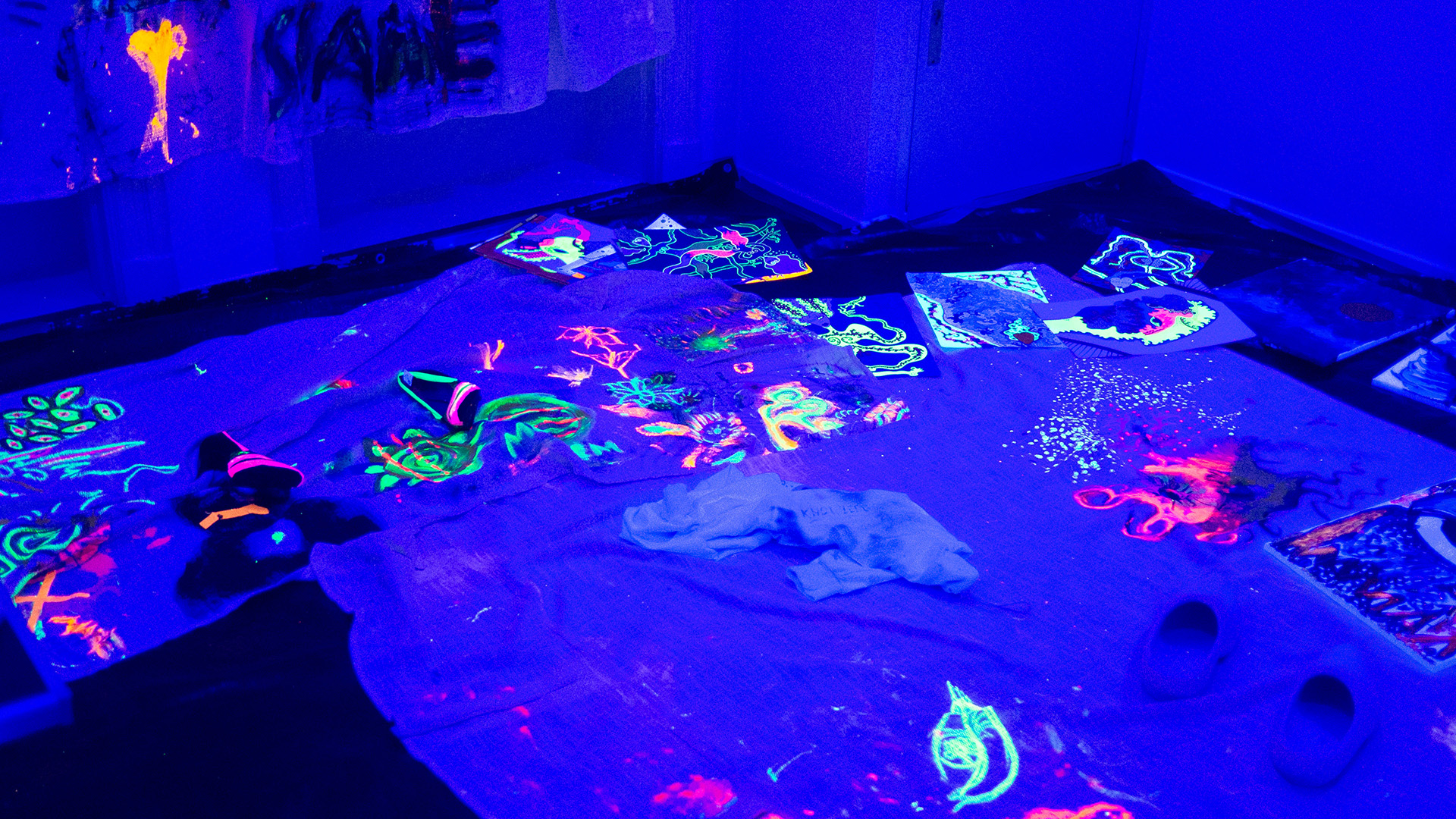 A room with blue light and bright coloured drawings.