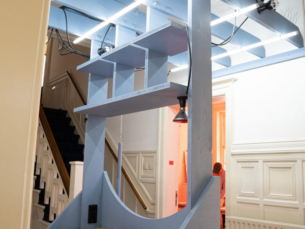installation of a grey or blue wooden panel with LED lights installed as a counter in the entrace of a space
