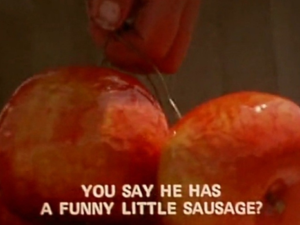 Two apples tide up together held by a hand.